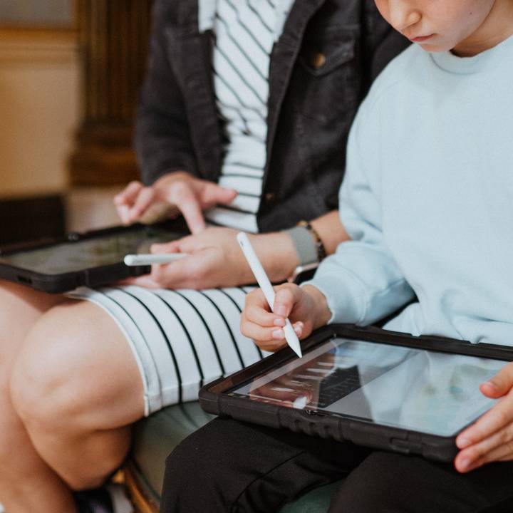 a child and woman on ipads